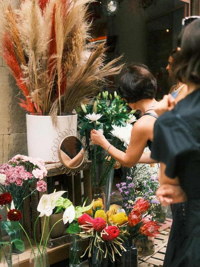 Fleuriste composant un bouquet dans sa boutique